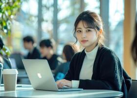 A woman sitting at a table with a laptop photo