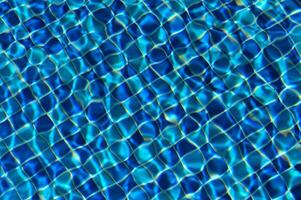 Dazzling patterns of sunlight dancing on a shimmering pool surface during a bright summer day photo