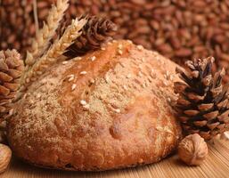 Freshly Baked Bread with Seeds and Spikes of Wheat on Rustic Background photo