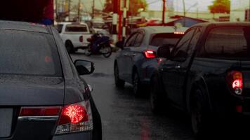 Rear side view of cars on the road. Sun is setting casting a warm glow on the scene. Cars are blurred suggesting movement and a sense of urgency. Busy and bustling environment. photo