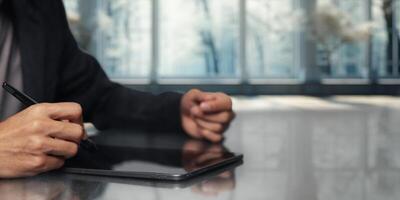 Person Using Digital Tablet and Stylus in Modern Office Environment photo