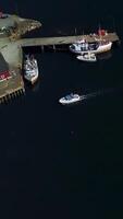 Aerial view of Pier with the ships in the port city. Lofoten archipelago in Norway, vertical footage video