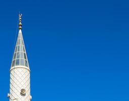 Mosque Minaret on a background of blue sky in Turkiye photo