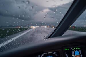 Cockpit view of jet during storm with glowing instruments and rain-streaked glass photo