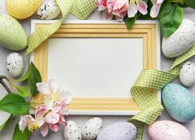 Easter eggs and spring flowers framing empty photo frame
