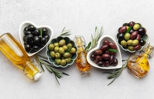 Black, green and kalamata olives with olive oil and olive branches mediterranean culinary scene photo