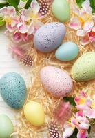 Easter eggs and spring flowers creating a frame on white background photo