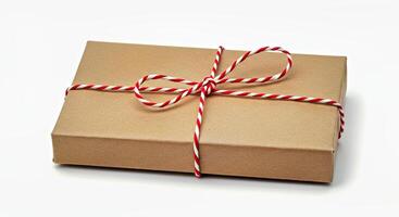 A brown box wrapped in twine tied with a red and white ribbon photo