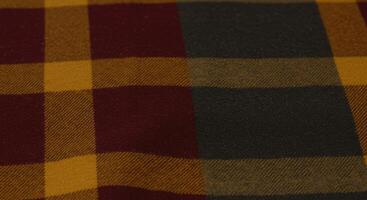 A close up of a red, yellow and black plaid fabric photo