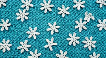 A close up of a knitted snowflake pattern on a blue background photo