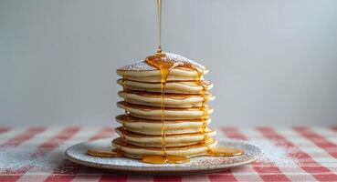 A stack of pancakes with syrup being poured over them photo