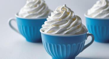 Three blue cups with whipped cream on top photo
