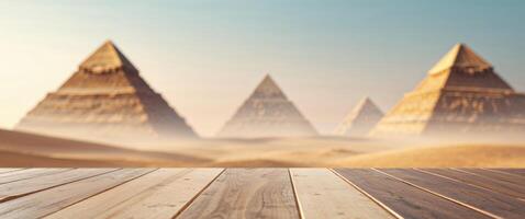 Wooden Table Top with Blurred Pyramids Background Shows Majestic Desert Landscape in the Sun. photo