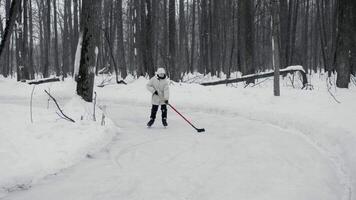 Tonårs pojke är praktiserande hans is skridskoåkning Kompetens på rink i parkera. han är påfrestande till träffa puck med hans skridskor och direkt den fram. pojke utför fint till lura hans motståndare. video