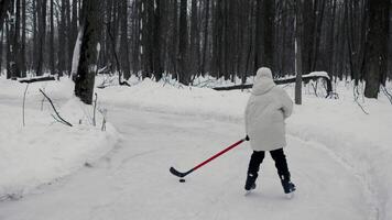 Teenage boy is practicing his skating at an ice rink in the park. However, he stumbles and falls on the ice, losing his balance and failing to maintain his balance. video