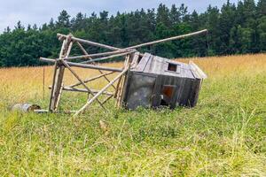 Hunting blind fallen to the ground, a wooden structure of a Hunting blind lying in a field photo
