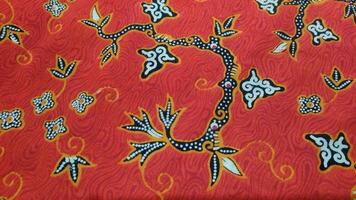 a red and black fabric with a floral design. photo