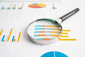 Magnifying glass on charts graphs paper. Financial development, Banking Account, Statistics, Investment Analytic re photo