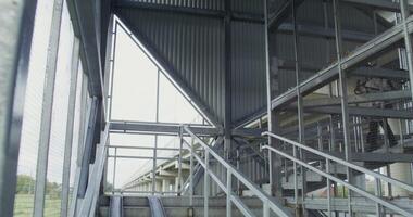 A man going down a metal stairway with a railing and a metal railing video