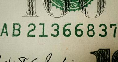 A close up of a hundred dollar bill with the numbers video