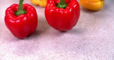 Three red and yellow peppers on a table video
