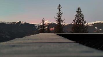Modern house in the mountains at night, warm lighting creates a cozy atmosphere, snow around adds contrast video