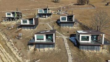 Modern hillside cabins with large glass windows, offering panoramic views of the valley, under construction in a remote countryside setting, blending nature with contemporary design video