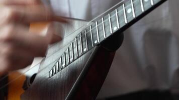 Hands strumming quickly on classic balalaika, playing quickly. Acoustic string musical instrument video