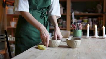 Potter hands skillfully crafting unique clay cup, bowls on workshop table with precise craftsmanship video