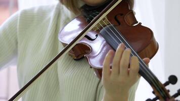 Woman playing violin rapidly with bow, with skilled technique and improving musical performance video