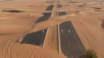 A desert road with sand dunes and trees in the background photo