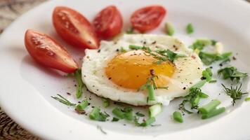 eggs for breakfast. Fried eggs with cherry tomatoes and greens for breakfast. video