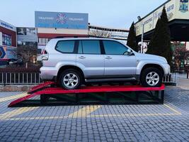 Lviv, Ukraine - February 12, 2025- Silver Toyota Prado SUV displayed on ramp in urban environment with business surroundings photo