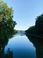 Historic Palace on the Isle surrounded by serene water and greenery under a clear sky photo