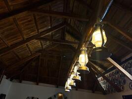 Rustic Wooden Ceiling With Hanging Lanterns in a Cozy Traditional Setting photo
