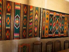 Colorful traditional textiles with geometric patterns displayed in a dining room setting photo