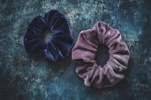 Two purple and blue scrunchies are on a blue surface photo