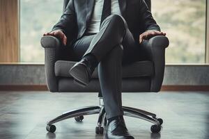 A man in a suit and tie sits in a chair photo