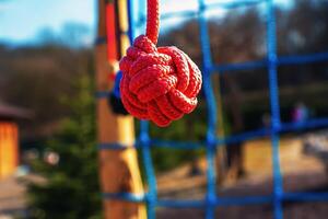 Close-up of a rope on a playground with a blurred background. Red rope. photo