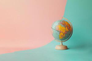 globe on a stand on a light pink and blue background photo