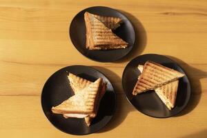 three sandwiches on plates on the table, lunch photo