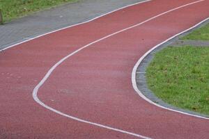 Running track curve with white lines and green grass photo