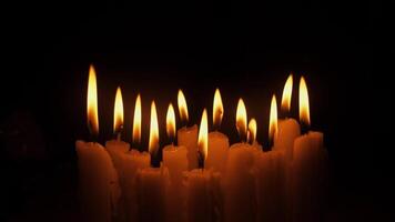 A serene and calming display of flickering candle flames shedding warm light into the surrounding darkness video