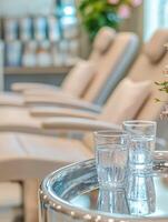 A table with two glasses of water and flowers photo
