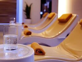 A white table with a glass of water and towels photo
