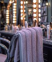 Soft microfiber towel hanging on a salon chair near bright mirrors photo