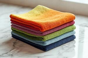 Soft microfiber towels stacked neatly on a marble surface photo