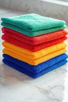 Colorful microfiber towels stacked neatly on a kitchen countertop photo