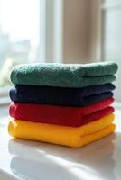 Soft microfiber towels stacked in vibrant colors on a surface photo