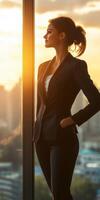 Business woman standing in front of window with city view photo